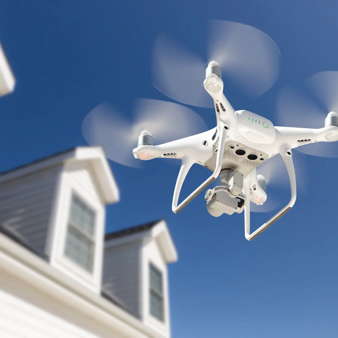 Photographie d'un drone inspectant une toiture d'habitation.